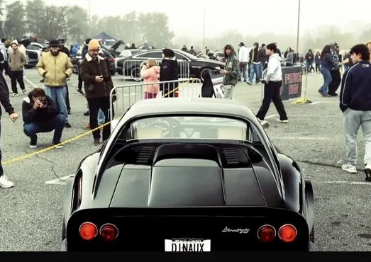 Rear three-quarter of the development car at a car show.