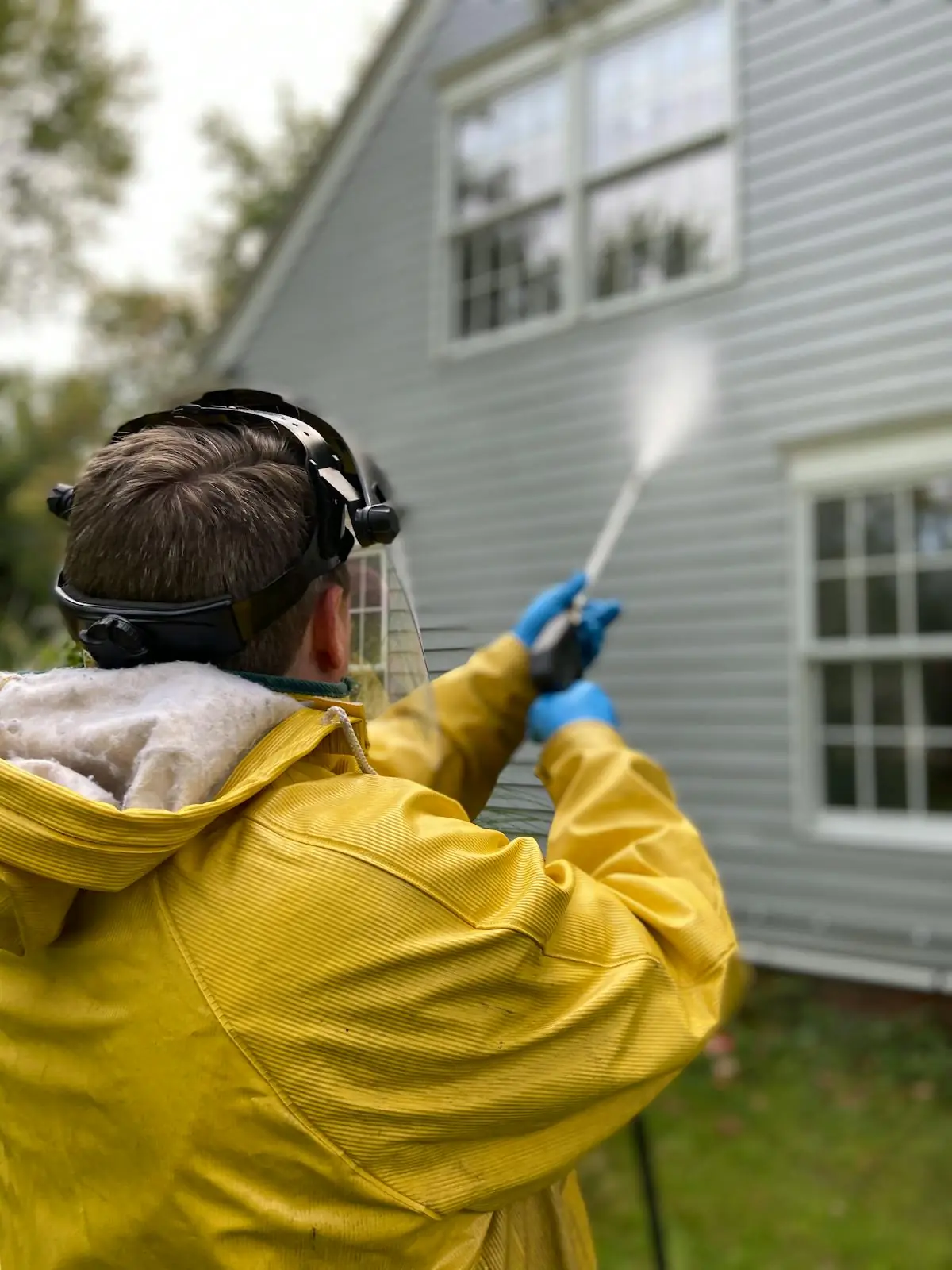 Pressure washing the siding of a home